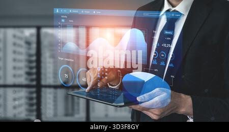 A businessman in a suit engages with a digital tablet, analyzing data trends through interactive infographics in a contemporary office setting. Impute Stock Photo