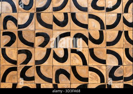 Square tiles forming a captivating pattern with black curves on a beige background, creating a visually appealing texture Stock Photo