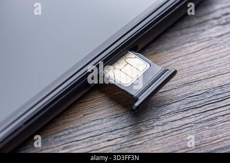 Inserting a modern nano SIM card into a Smartphone Stock Photo