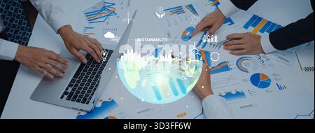 Diverse professionals engage in a collaborative effort focused on sustainability, utilizing data visuals and technology to drive innovative solutions Stock Photo