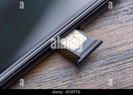Inserting a modern nano SIM card into a Smartphone Stock Photo