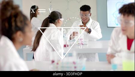 Transferring liquids students in lab coats and goggles at school lab, using pipettes and test tubes Stock Photo