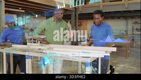 Collaborating three men in work shirts inspecting wooden planks in woodshop, with AR charts Stock Photo