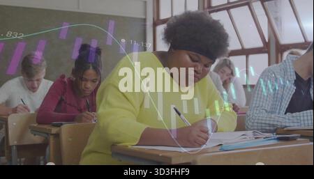 Writing African American student in yellow top taking notes in classroom, with projected bar charts Stock Photo
