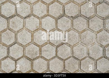 Full Frame Top Down View of Old Weathered Beige Hexagonal Concrete Paving Stones Forming a Geometric Honeycomb Pattern Stock Photo