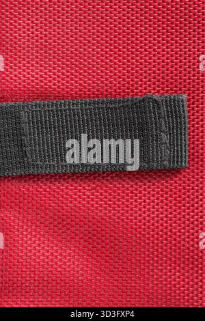 Black blank patch stitched on red waterproof fabric background Stock Photo