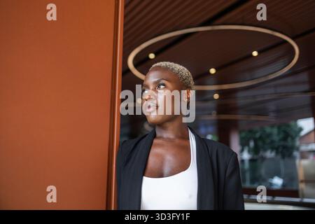 Businesswoman with a confident expression stands in a modern office, showcasing her leadership qualities. She exudes professionalism as a CEO in a con Stock Photo