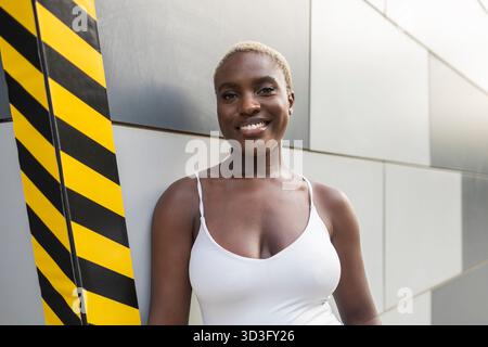 A confident businesswoman and CEO smiles warmly while standing outdoors against a modern urban backdrop, embodying leadership and professionalism in t Stock Photo