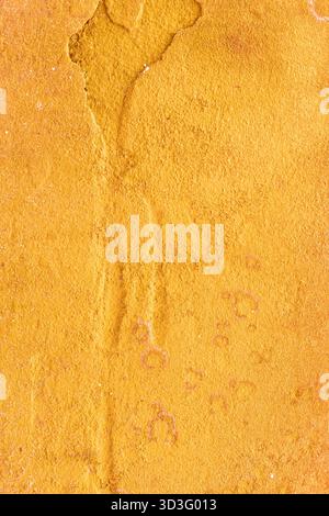 A detailed close-up of a natural yellow stone surface, showcasing its rough texture and irregular patterns. The earthy tones create an organic abstrac Stock Photo
