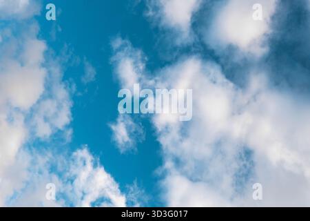 A vibrant blue sky is filled with fluffy white clouds, creating a serene and calming scene that captures the beauty of nature's ever-changing patterns Stock Photo