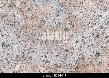 A close-up of a textured concrete surface showcasing a mix of gray, brown, and speckled patterns. The image captures the rough, natural appearance of Stock Photo