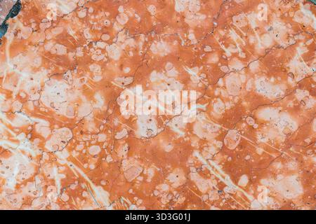 A vibrant orange marble surface showcases intricate patterns and natural cracks, creating an artistic blend of colors. Perfect for design backgrounds Stock Photo