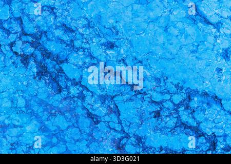 Close-up of a striking blue marble texture displaying intricate vein patterns and a smooth, polished surface. The vibrant blue color highlights the na Stock Photo