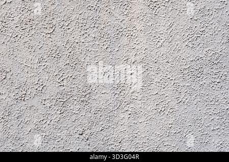 Detailed close-up of a textured white plaster surface, showcasing an intricate pattern and rough texture. Ideal for backgrounds or design inspirations Stock Photo