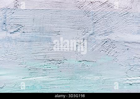 Close-up of a textured wall featuring a combination of wooden and brick surfaces. The wall displays a pastel paint finish with hints of white and ligh Stock Photo