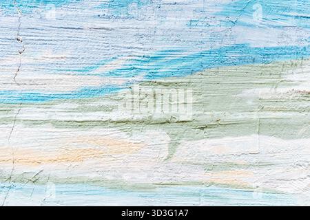 A textured wall painted in soft pastel colors with flowing patterns in blue, green, and peach, creating a serene and artistic atmosphere. Visible crac Stock Photo