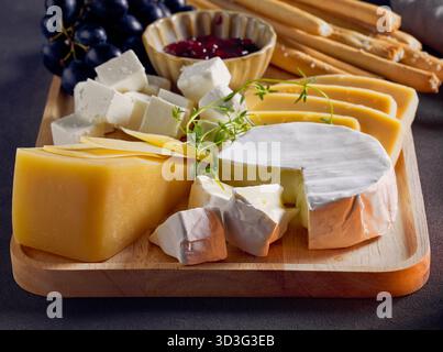 cheese plate and bread sticks on dark grey table background Stock Photo