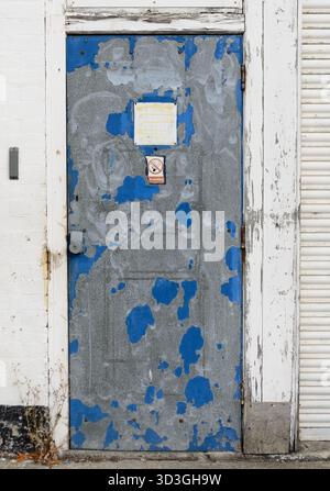 old wooden front door with peeling blue paint UK Stock Photo
