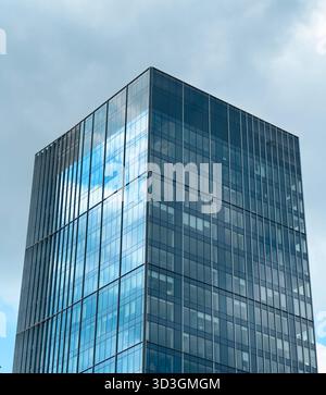 Skyscraper tower rising in modern metropolis. Futuristic glass building with reflective facade symbolizing global finance, corporate architecture, rea Stock Photo