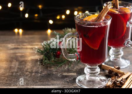 Mulled Wine with Orange and Cinnamon Sticks and Christmas decoration on wooden table Stock Photo