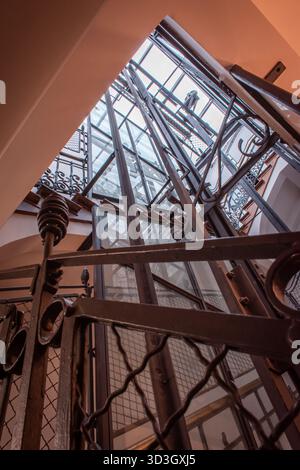 A vintage creaky elevator with wooden panels, glass walls, and metal gates. Stock Photo