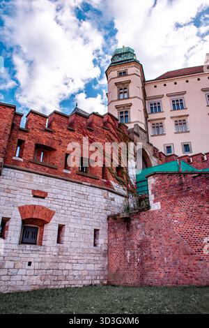 A building surrounded by a wall made of red and white bricks. A view from below of the towers. Stock Photo