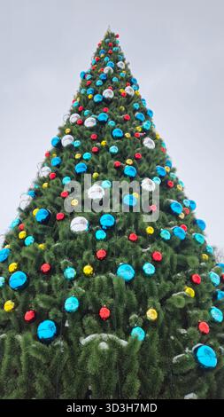 Large Christmas tree decorated with multi-colored balls, view from below Stock Photo