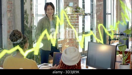 Collaborating women developers writing code on glass panel in loft office, laptops, copy space Stock Photo