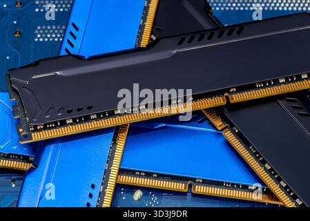Four DDR memory chips in different colors lying on a blue printed circuit board. Stock Photo