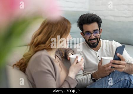 Affectionate loving married couple drinking coffeee, enjoying spending time together at home, relaxing, sweet tender moment Stock Photo