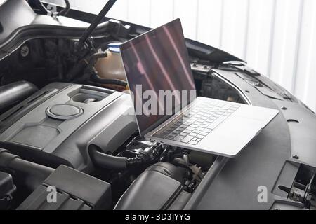 Services car engine machine concept, Automobile mechanic repairman checking a car engine with using computer diagnostics while repairing, car service Stock Photo