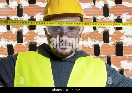 Engineer Do it yourself, man dressed in yellow builder helmet with protective glasses ready to start the construction work Stock Photo