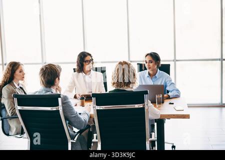 Business meeting of diverse coworkers collaborating on a project in an elegant modern office workspace Stock Photo