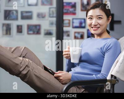 Young women use tablets at home with smile Stock Photo