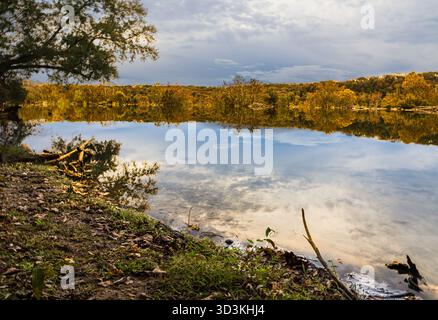 Autumn Reflections of clouds and sky on the calm water of the Potomac River seen from the River Trail Stock Photo