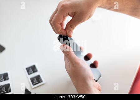 The process of replacing a protective glass on a smartphone Stock Photo