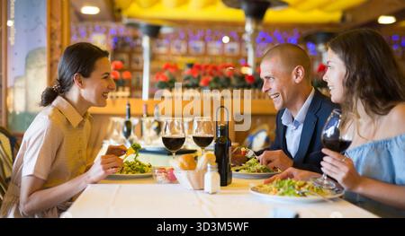 Two cheerful couples having dinner and nice talking Stock Photo