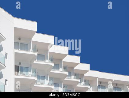 Modern apartment building with repetitive balconies and glass railings against a blue sky abstract,  geometric patterns, can pastilla, mallorca, spain Stock Photo