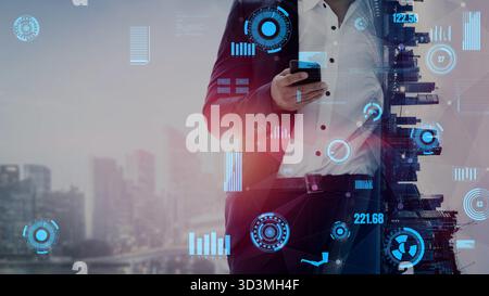 A business professional interacts with a smartphone amidst a futuristic city background featuring digital holograms, showcasing themes of technology Stock Photo