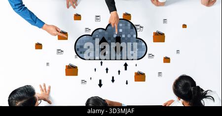 A collaborative workspace featuring hands over a digital table with a cloud storage icon and file symbols, emphasizing teamwork in data management and Stock Photo