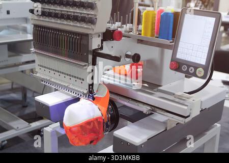 Automatic embroidery machine embroiders on clothes. Garment industry Stock Photo