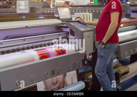 Printer operating printing machine in printing house. Industry Stock Photo