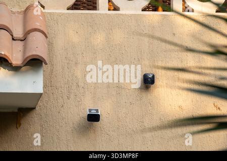 Technology comparison of two mounted outdoor wireless security cameras: Amazon's blink and Eufy solar-powered S220 Stock Photo