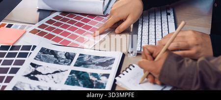 A creative workspace scene showcasing designers collaborating on color palettes, analyzing swatches, and jotting notes for their next artistic project Stock Photo