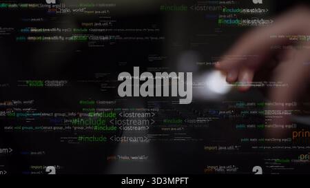 Visual representation of programming code flowing on a screen with a hand engaging with modern technology, showcasing the blend of creativity and Stock Photo