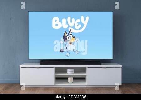 A widescreen OLED television showing the intro scene to the children's TV series Bluey, seen in a contemporary living room. Stock Photo