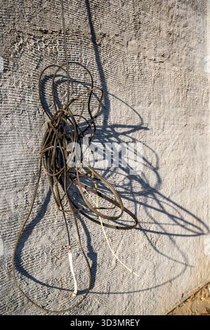 A close-up of colorful decorative threads and elastic bands arranged in a tangled, festive pattern. The composition includes metal wire, rubber cords, Stock Photo