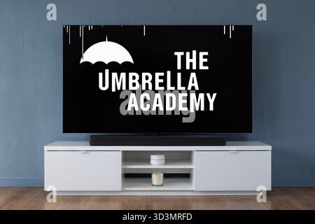 A widescreen OLED television showing the intro scene to the TV series The Umbrella Academy, seen in a contemporary living room. Stock Photo