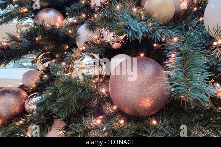Close-up shot of rosegold, gold and cream colored baubles on a decorated Christmas tree in a shopping mall in Budapest, Hungary called Allee Stock Photo