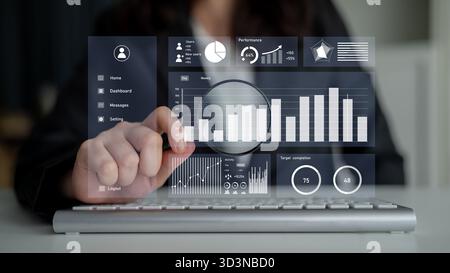 A business professional examines performance metrics using an interactive touchscreen interface with various graphs and charts in a modern office Stock Photo